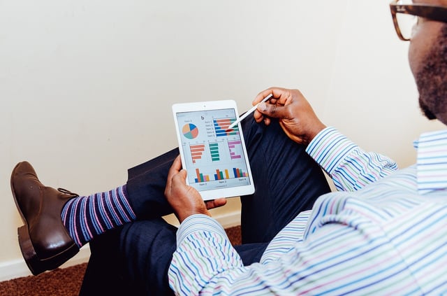 Man looking at charts and graphs on tablet